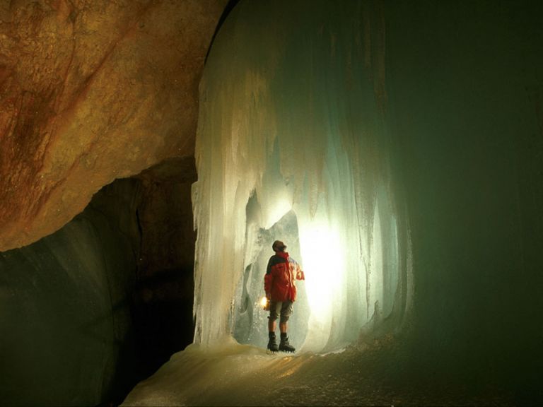 Ein Mensch steht in einer Eishöhle