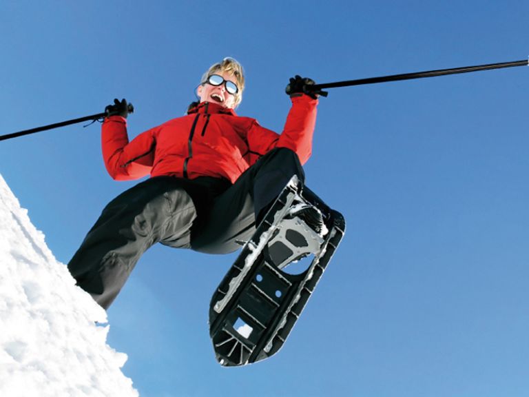 Frau beim Schneeschuhwandern von Unten fotografiert